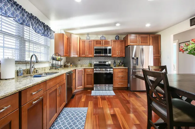 a kitchen with stainless steel appliances a refrigerator a sink a stove a microwave and cabinets