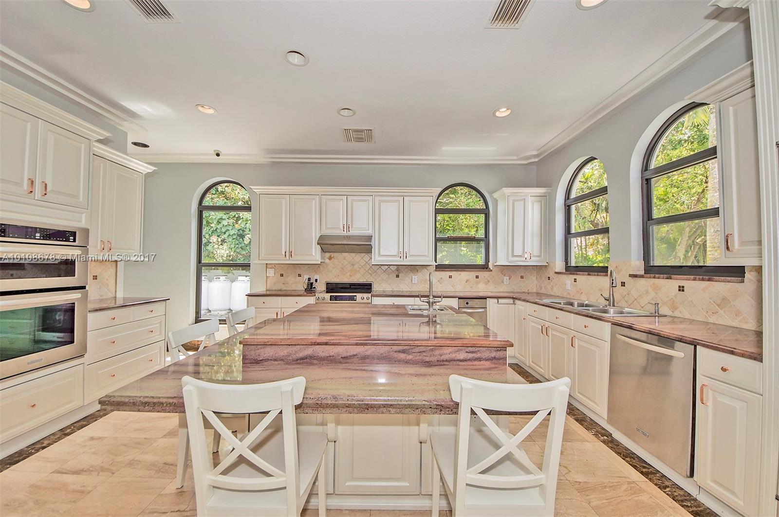 10270 Southwest 58th Street Miami, FL 33173 - Photo 11 of 35 a large kitchen with a window a sink and cabinets