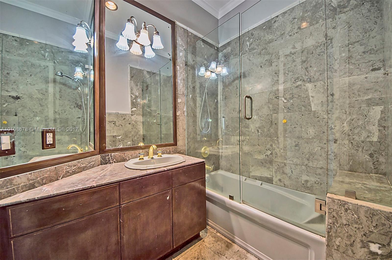 10270 Southwest 58th Street Miami, FL 33173 - Photo 29 of 35 a bathroom with a granite countertop sink a mirror a bathtub and shower
