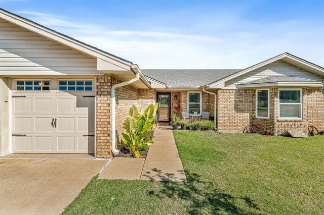 a view of a house with a yard and pathway