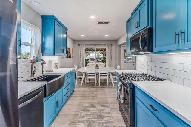 a kitchen with stainless steel appliances granite countertop a stove a sink and a microwave