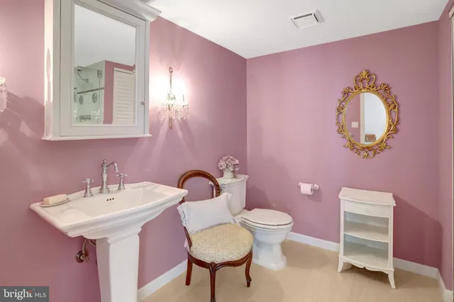 a bathroom with a sink vanity mirror and toilet