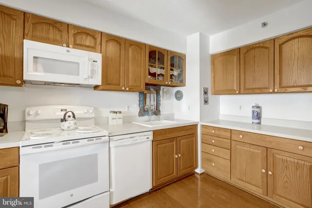 a view of a kitchen with fridge and wooden floor