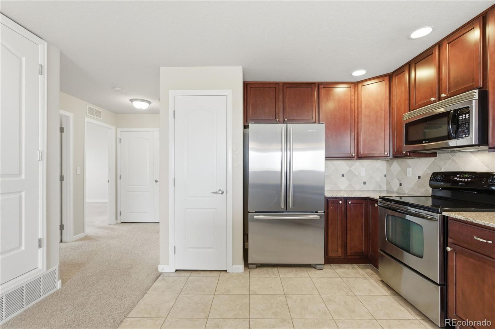 6223 Kilmer Loop, Unit 201 Golden, CO 80403 - Photo 11 of 44 a kitchen with stainless steel appliances granite countertop a refrigerator and a stove top oven