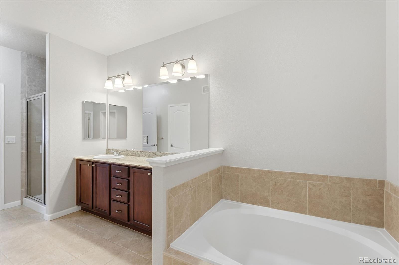 6223 Kilmer Loop, Unit 201 Golden, CO 80403 - Photo 14 of 44 a bathroom with a tub sink and mirror