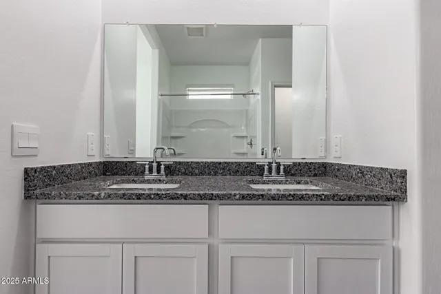 a bathroom with a granite countertop sink and a mirror