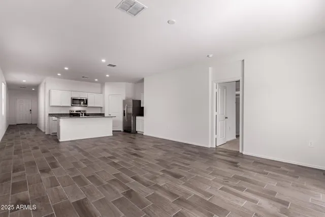 a view of kitchen with granite countertop a refrigerator and a sink