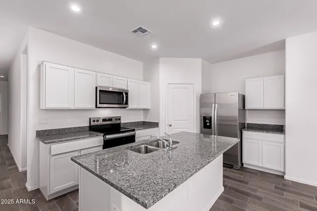a kitchen with stainless steel appliances granite countertop a sink stove and refrigerator