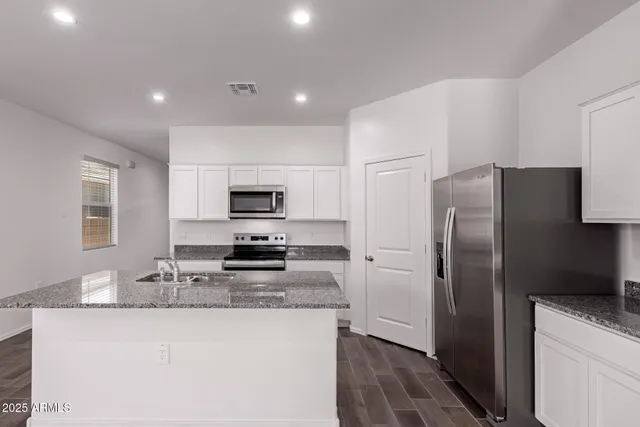 a kitchen with stainless steel appliances granite countertop a refrigerator stove microwave and sink