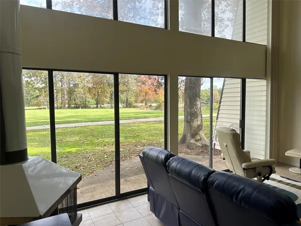 a living room with furniture and a floor to ceiling window