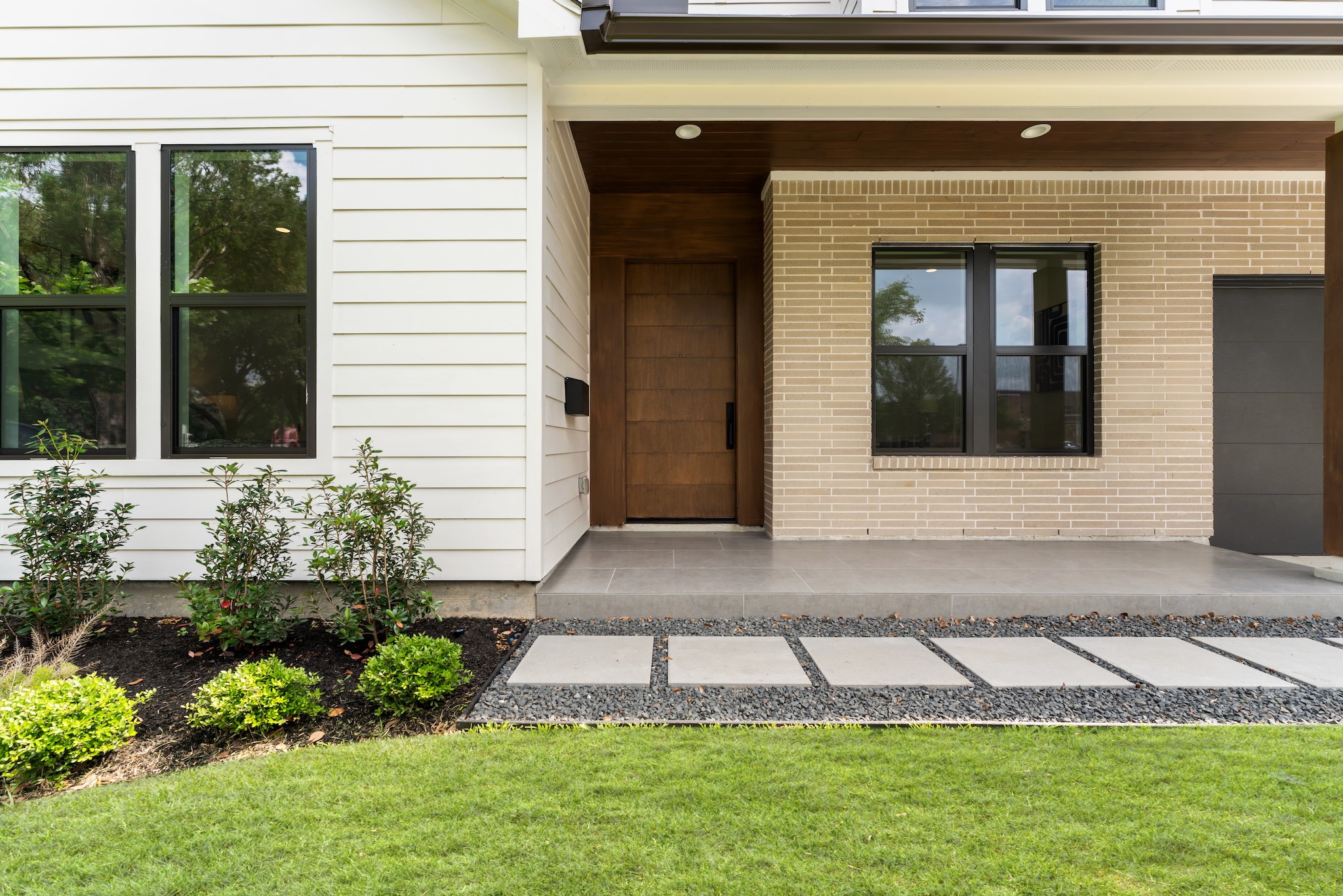6711 Housman Houston, TX 77055 - Photo 2 of 49 Custom wood door, designer brick and lap siding, and an inviting front porch hint at the sophisticated warmth waiting inside.