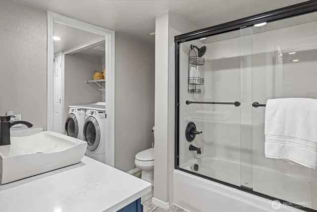 a bathroom with a bathtub sink mirror and toilet