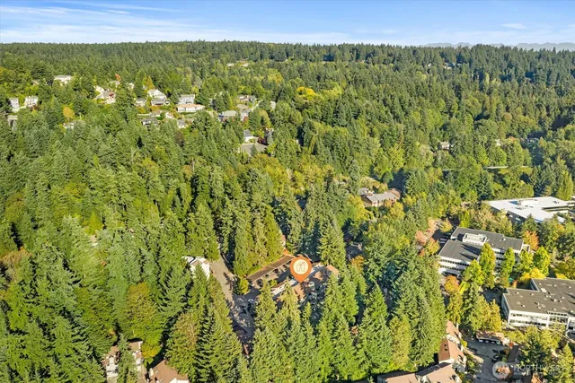 a view of a white house with a large window and potted plants
