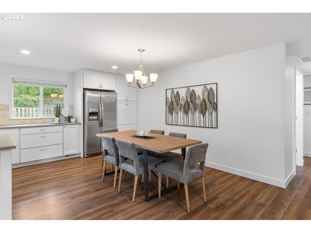 14720 Southwest Glenbrook Road Beaverton, OR 97007 - Photo 14 of 43 a dining room with wooden floor a chandelier a wooden table and chairs