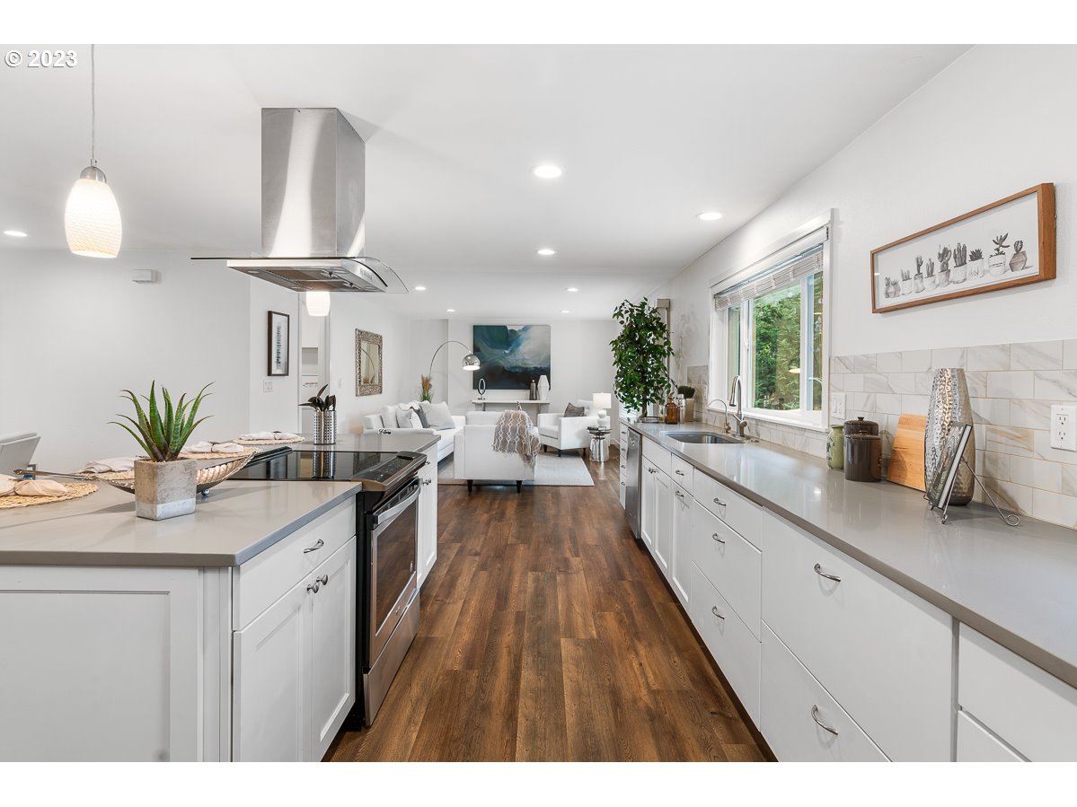 14720 Southwest Glenbrook Road Beaverton, OR 97007 - Photo 18 of 43 a large kitchen with kitchen island granite countertop a large counter space a sink appliances and cabinets