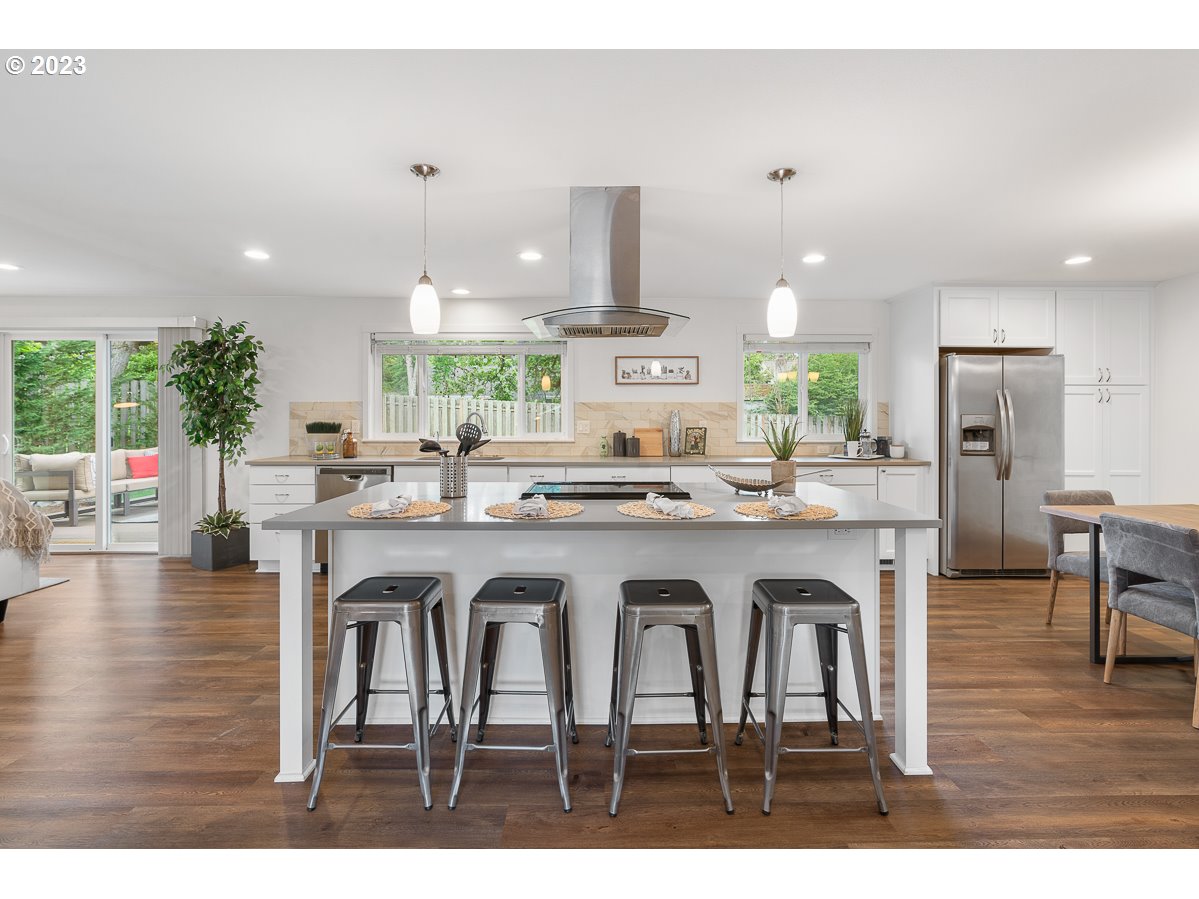 14720 Southwest Glenbrook Road Beaverton, OR 97007 - Photo 10 of 43 a large white kitchen with granite countertop a stove a sink a window and chairs