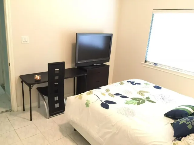 a bedroom with a bed and a flat screen tv
