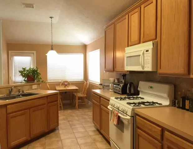 a kitchen with a sink stove and cabinets
