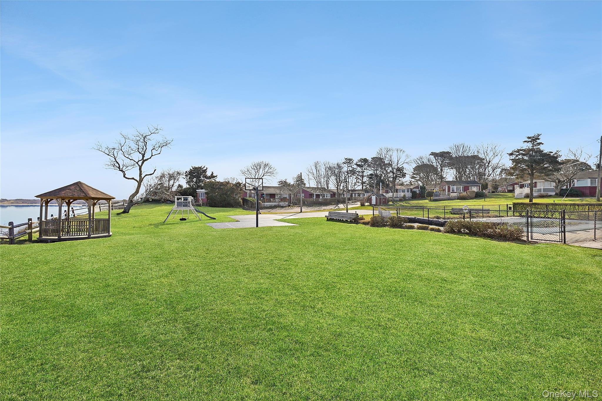 67 North Road, Unit A Hampton Bays, NY 11946 - Photo 14 of 17 a view of a house with a big yard and potted plants