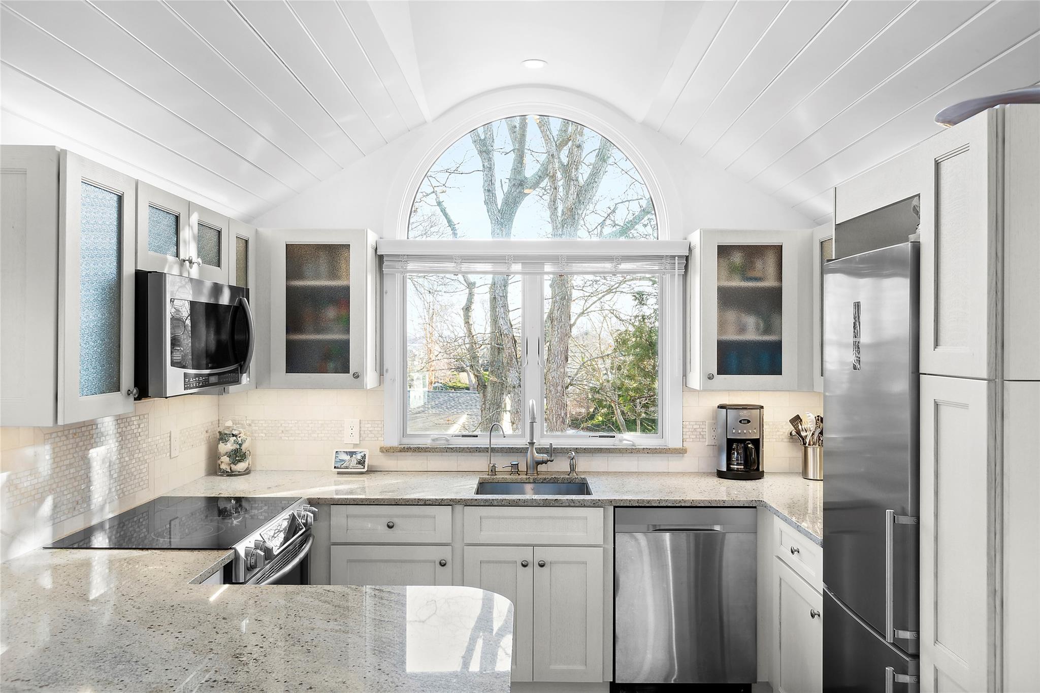 67 North Road, Unit A Hampton Bays, NY 11946 - Photo 6 of 17 Kitchen featuring a sink, appliances with stainless steel finishes, lofted ceiling, healthy amount of natural light, and light stone counters