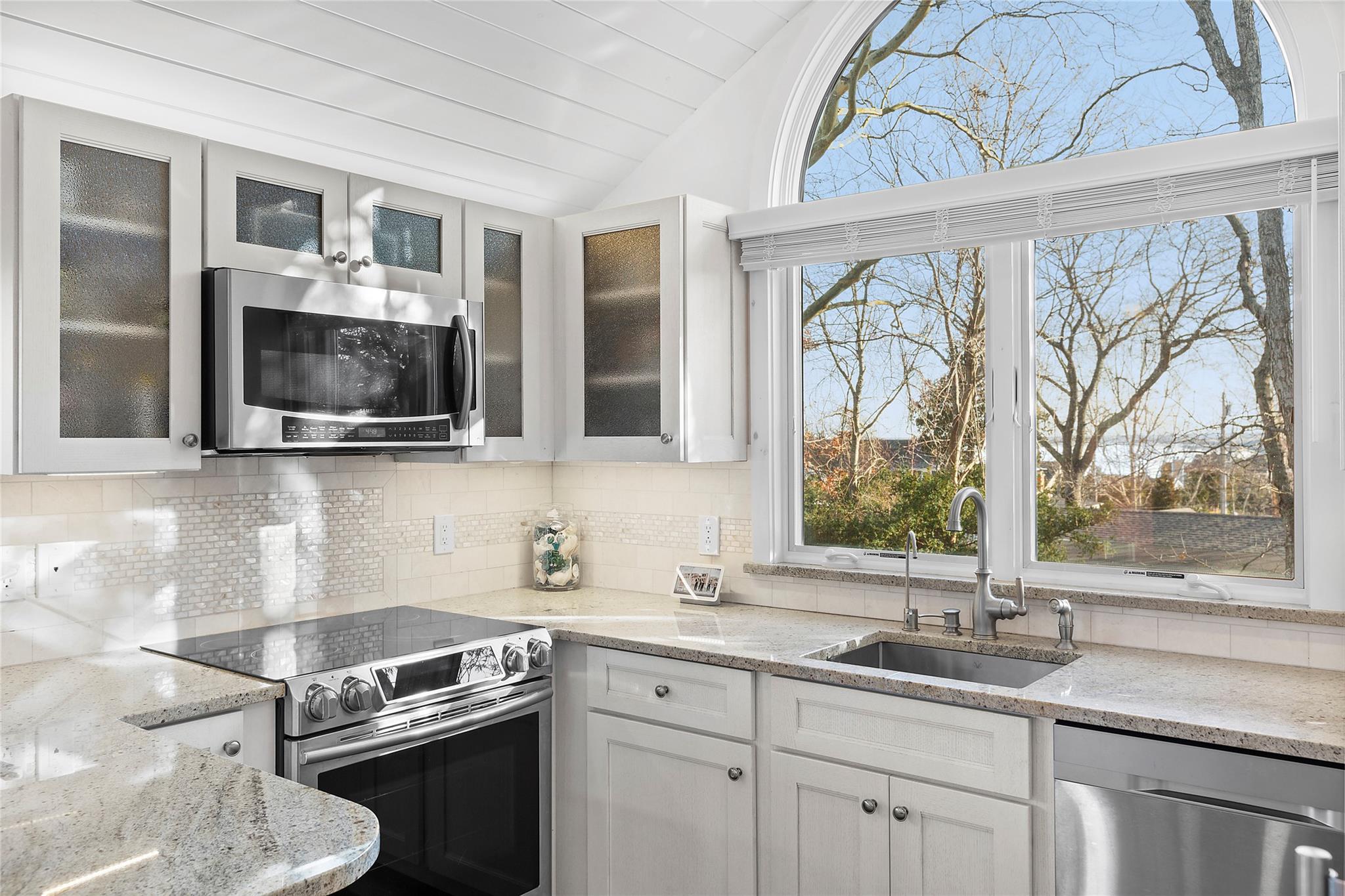 67 North Road, Unit A Hampton Bays, NY 11946 - Photo 7 of 17 Kitchen with appliances with stainless steel finishes, a sink, lofted ceiling, decorative backsplash, and white cabinets