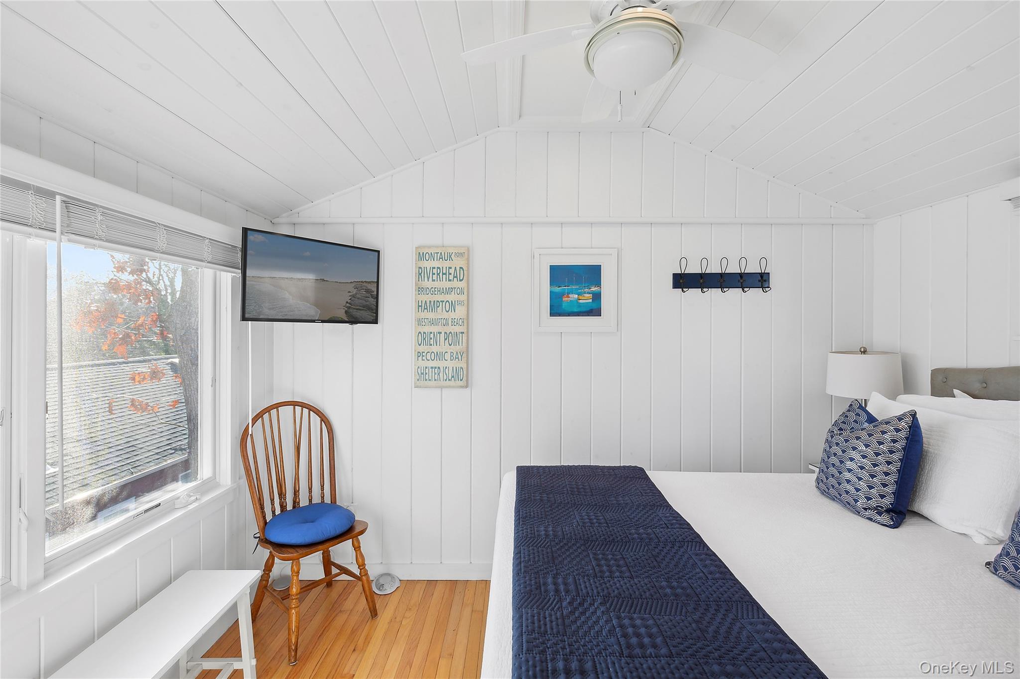 67 North Road, Unit A Hampton Bays, NY 11946 - Photo 10 of 17 a bedroom with a bed and a chandelier