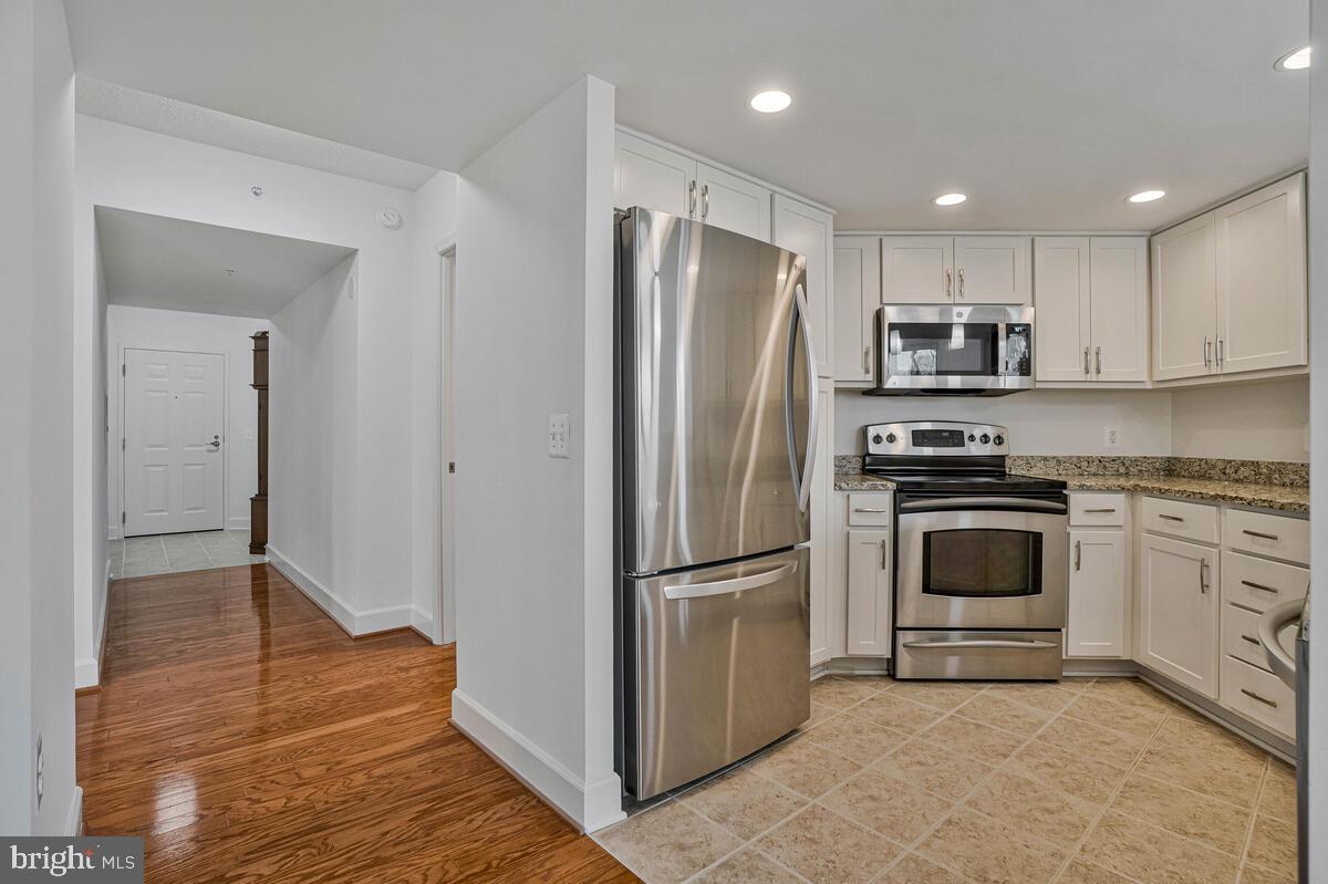 11800 Sunset Hills Road, Unit 514 Reston, VA 20190 - Photo 28 of 57 a kitchen with stainless steel appliances granite countertop a refrigerator and a stove top oven