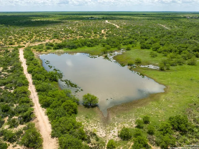 a backyard of a house with lots of green space and lake view