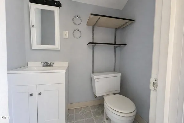 a bathroom with a toilet sink vanity and shower
