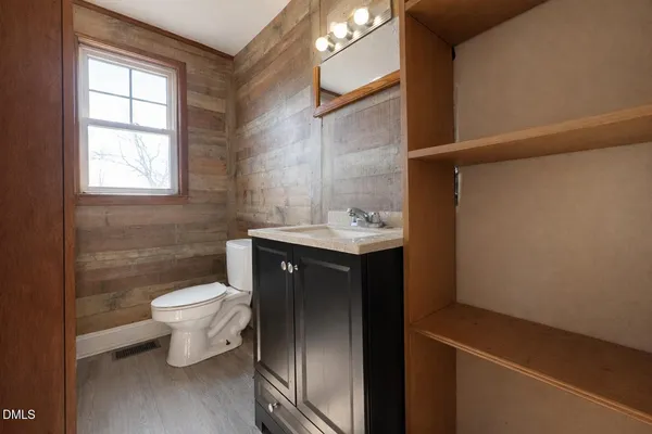 a bathroom with a sink toilet and window