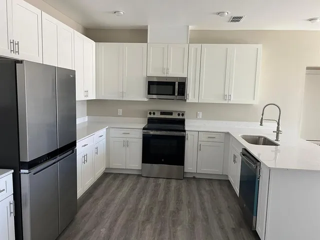 a kitchen with white cabinets and stainless steel appliances