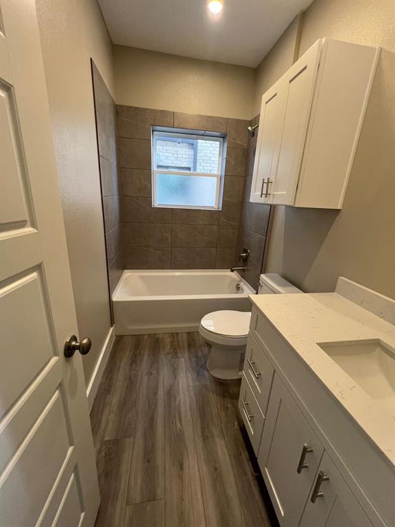 443 Richlands Way Fate, TX 75087 - Photo 18 of 20 Full bathroom with dark wood finished floors, vanity, shower / washtub combination, and a textured wall
