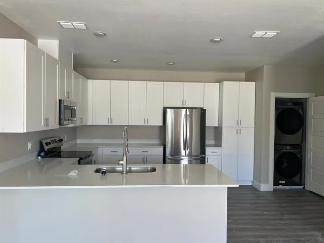 a kitchen with kitchen island a sink stainless steel appliances and cabinets