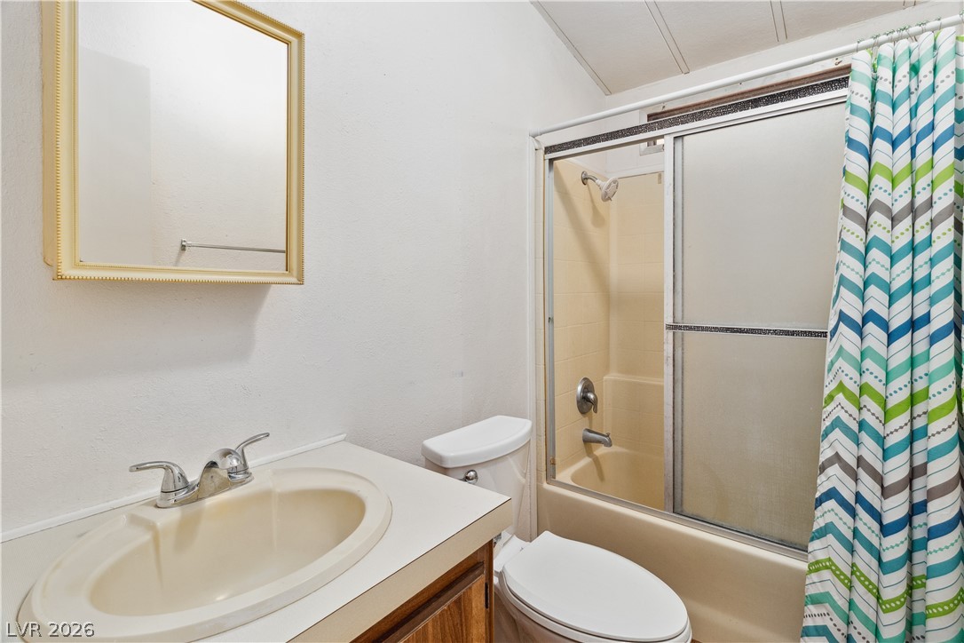 1671 Granada Street Laughlin, NV 89029 - Photo 18 of 63 Bathroom featuring toilet, shower / bath combination with glass door, and vanity