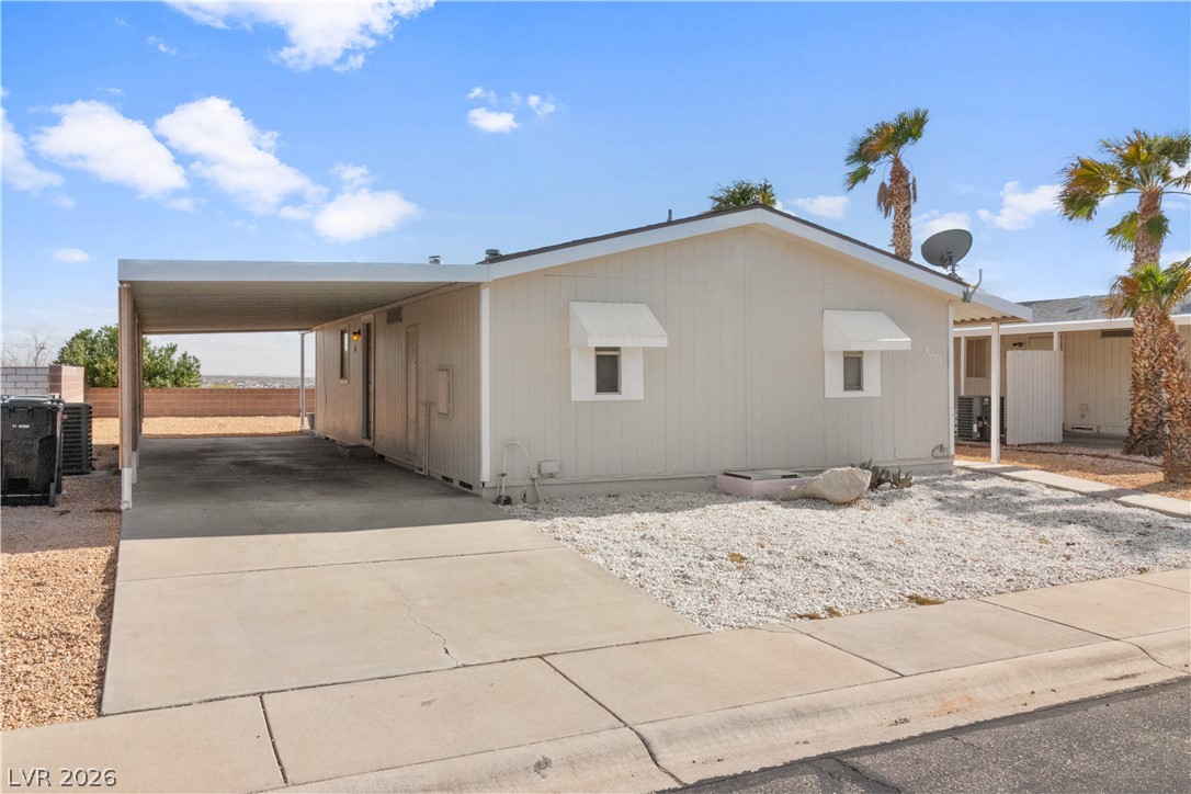 1671 Granada Street Laughlin, NV 89029 - Photo 29 of 63 View of side of property with central AC unit, an attached carport, and concrete driveway