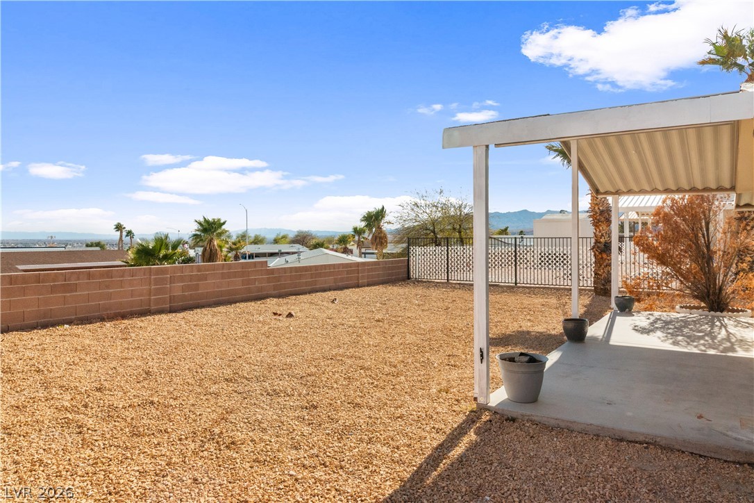 1671 Granada Street Laughlin, NV 89029 - Photo 35 of 63 View of yard with a patio area, a fenced backyard, and a mountain view