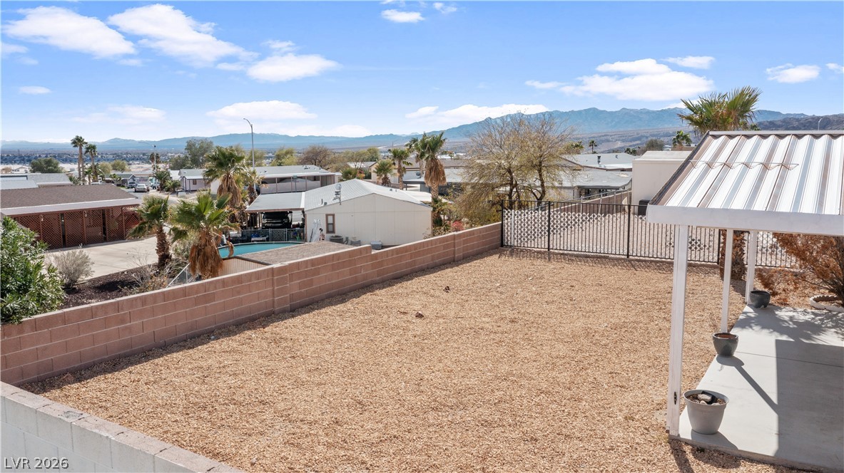 1671 Granada Street Laughlin, NV 89029 - Photo 52 of 63 View of yard featuring a residential view, a fenced backyard, and a mountain view