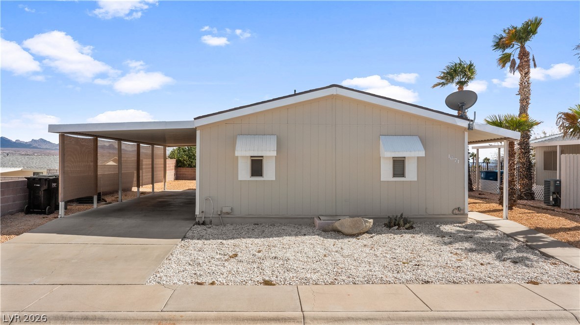 1671 Granada Street Laughlin, NV 89029 - Photo 59 of 63 View of home's exterior with driveway, an attached carport, and fence