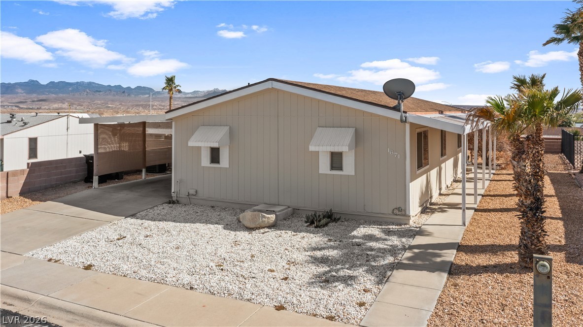 1671 Granada Street Laughlin, NV 89029 - Photo 60 of 63 View of side of property featuring a mountain view, an attached carport, and concrete driveway