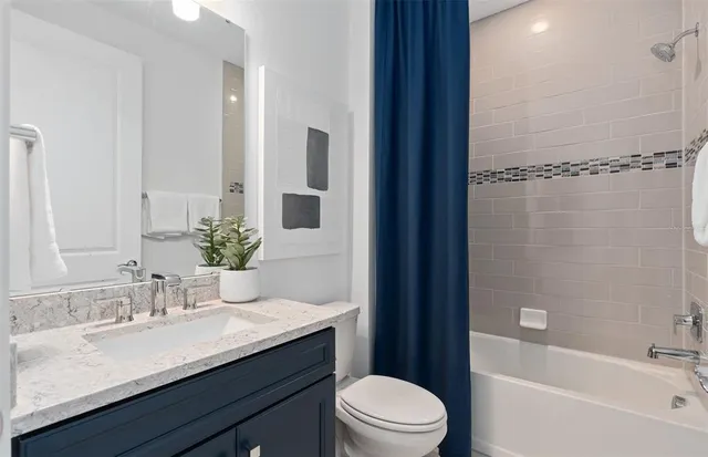 a bathroom with a granite countertop sink toilet a large mirror a shower and a bathtub