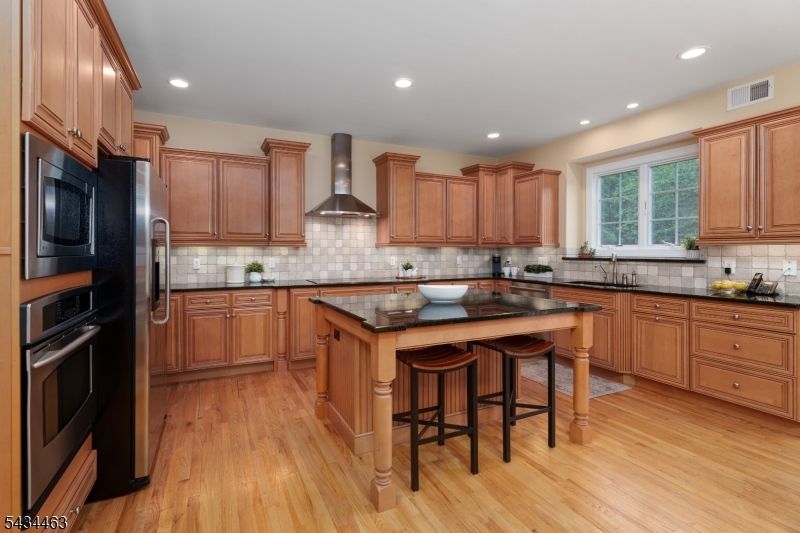 110 Orchard Road Skillman, NJ 08558 - Photo 9 of 43 a kitchen with kitchen island granite countertop wooden floors appliances and cabinets