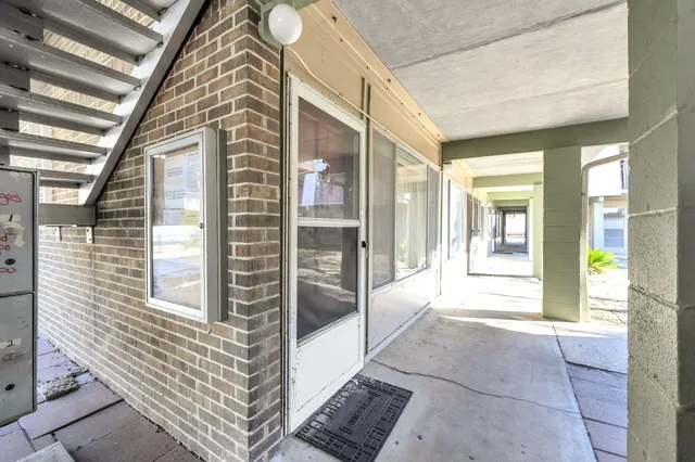 a view of a swimming pool with a lawn chairs under an umbrella
