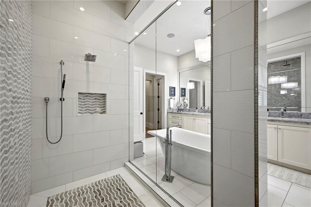 215 3rd Avenue North Naples, FL 34102 - Photo 16 of 47 Bathroom with two vanities, walk in shower, a soaking tub, light tile patterned floors, and recessed lighting