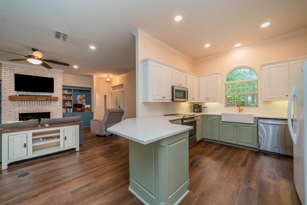 234 Spring Lake Knoll Trail Holly Lake Ranch, TX 75765 - Photo 6 of 20 a kitchen with stainless steel appliances granite countertop a stove top oven a sink dishwasher and a refrigerator with wooden floor
