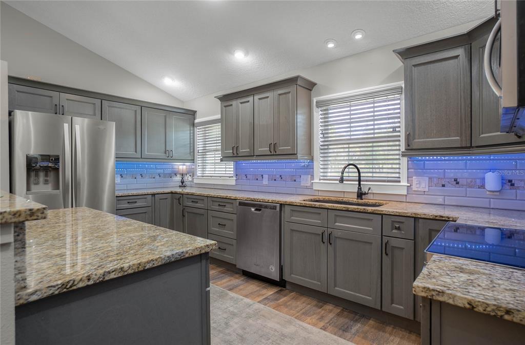 5466 West Tortuga Loop Lecanto, FL 34461 - Photo 14 of 41 a kitchen with granite countertop kitchen island stainless steel appliances a sink stove and cabinets