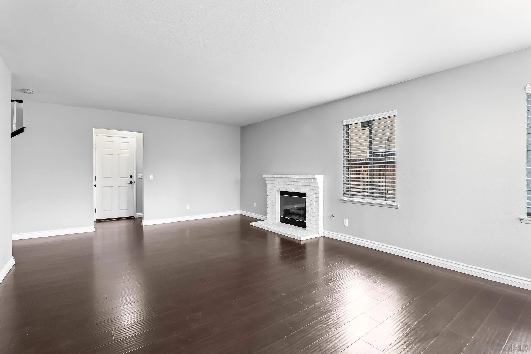 39884 North General Kearny Road Temecula, CA 92591 - Photo 16 of 58 an empty room with wooden floor fireplace and windows