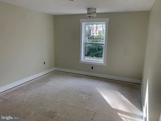 an empty room with a window and a ceiling fan