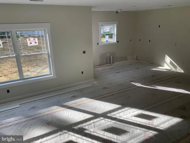 a view of a livingroom with an empty space & window