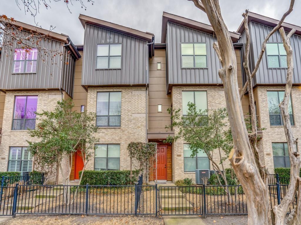 4211 Rawlins Street, Unit 528 Dallas, TX 75219 - Photo 1 of 14 Modern townhome with contemporary brick and vertical siding facade, featuring prominent windows and a distinctive angled roofline