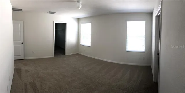 a view of small space with wooden floor and mirror